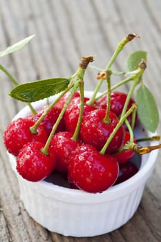 Cherries with stem and leaves in a bowl