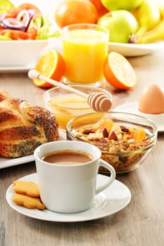 Breakfast including coffee, bread, honey, orange juice, muesli and fruits
