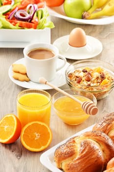 Breakfast including coffee, bread, honey, orange juice, muesli and fruits
