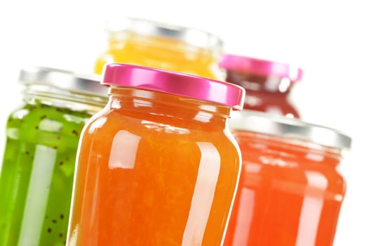Jars of fruity jams isolated on white background. Preserved fruits
