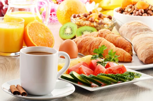Breakfast with coffee, orange juice, croissant, egg, vegetables and fruits