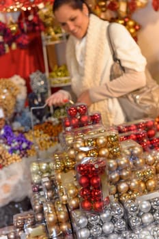 Pile of Christmas balls in plastic boxes woman shopping