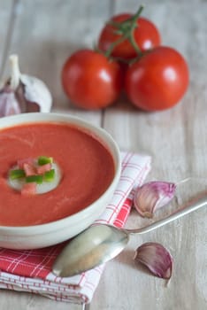 A bowl with gazpacho soup on a wooden background
