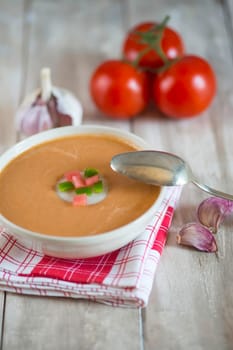 A bowl with gazpacho soup on a wooden background