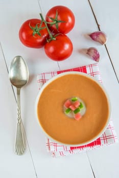 A bowl with gazpacho soup on a wooden background