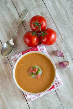 A bowl with gazpacho soup on a wooden background