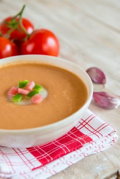 A bowl with gazpacho soup on a wooden background