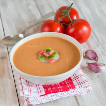 A bowl with gazpacho soup on a wooden background