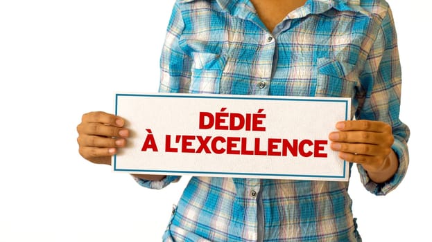 A woman holding a Dedicated To Excellence sign.