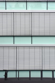 The photograph of a modern house façade in front of which stands a bicycle.