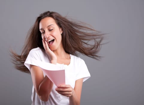 Passionate young woman falling in love reading a pink love letter