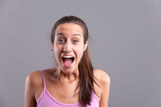 Happy girl cheering surprised looking at camera