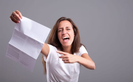 Angry girl pointing out a  letter containing bad news or something upsetting