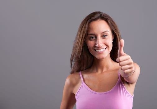Mediterranean beautiful girl smiling and expressing positivity with her OK thumbs up