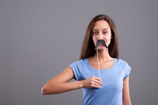 Very cute girl with a sly smile and fake mustache