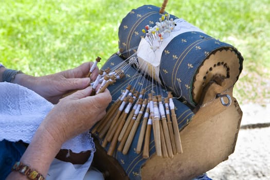 Close-up of an elderly spanish woman demonstrating the intricate art of making pillow lace or bobbin lace.