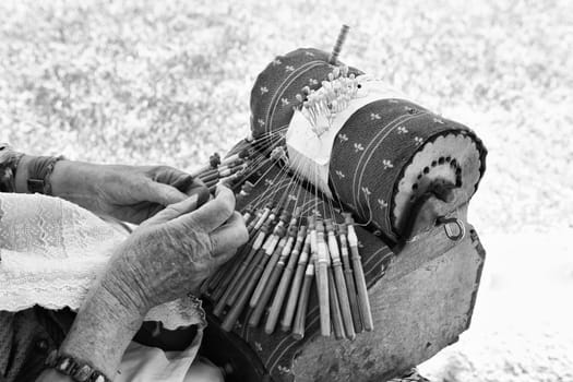 Close-up of an elderly spanish woman demonstrating the intricate art of making pillow lace or bobbin lace.
