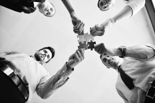 Group of business people assembling jigsaw puzzle and represent team support and help concept