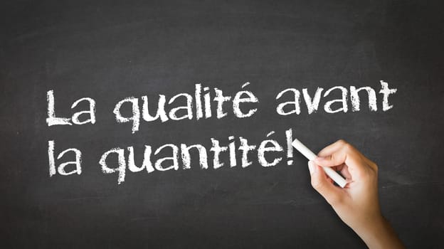 A person drawing and pointing at a Quality over Quantity Chalk Illustration