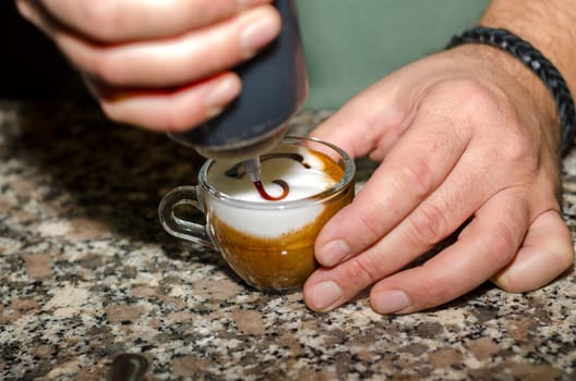 hands while decorating a coffee in Italy