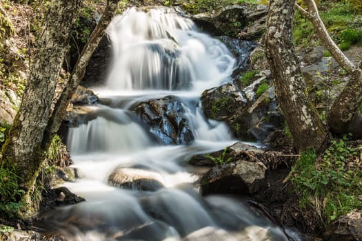 Cascades on a mountain river with a silky effect on the water that conveys a sense of relaxation.