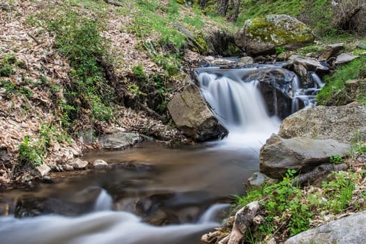 Cascades on a mountain river with a silky effect on the water that conveys a sense of relaxation.