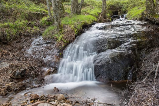 Cascades on a mountain river with a silky effect on the water that conveys a sense of relaxation.