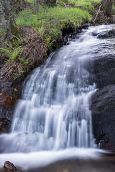 Cascades on a mountain river with a silky effect on the water that conveys a sense of relaxation.