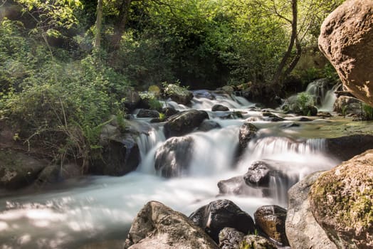 Cascades on a mountain river with a silky effect on the water that conveys a sense of relaxation.