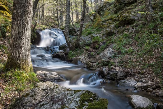 Cascades on a mountain river with a silky effect on the water that conveys a sense of relaxation.