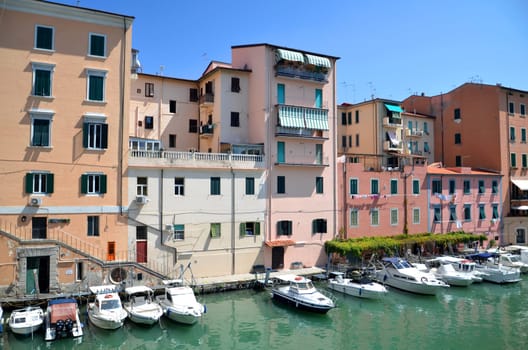 Picturesque view on boats in city channel in Livorno, Italy