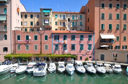 Picturesque view on boats in city channel in Livorno, Italy