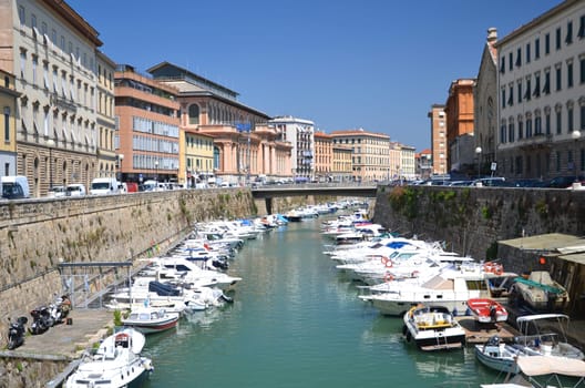 Picturesque view on boats in city channel in Livorno, Italy