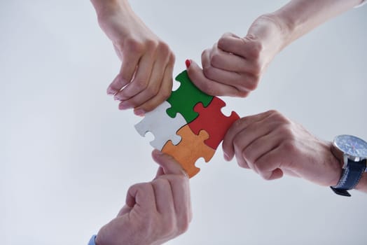 Group of business people assembling jigsaw puzzle and represent team support and help concept