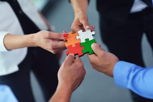 Group of business people assembling jigsaw puzzle and represent team support and help concept