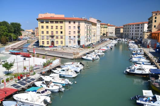 Picturesque view on boats in city channel in Livorno, Italy