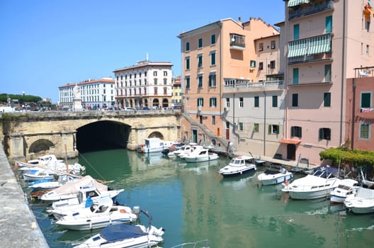 Picturesque view on boats in city channel in Livorno, Italy