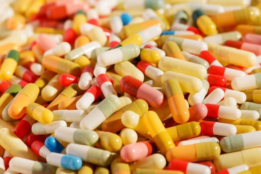 Tens of different colorful pharmaceutical pills or capsules in closeup in a full frame background texture for medical and healthcare concepts