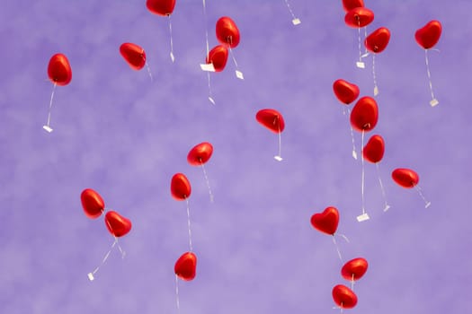 A group of beautiful heart ballons in front of a purple sky. Perfect for illustrating e.g. weddings, Valentine's Days or anniversaries.
