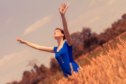 Happy girl feeling lucky and free with hands up. Nice perspective from bottom up.