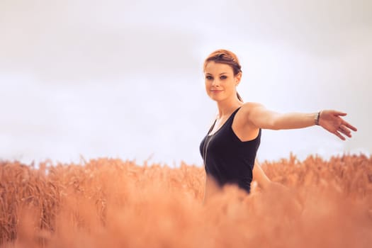 Natural picture of a good looking and lucky girl walking through a meadow. With a lot of copyspace.