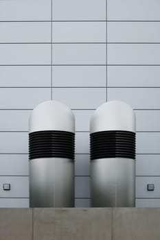 The photograph of two ventilation hoods in front of a modern building.