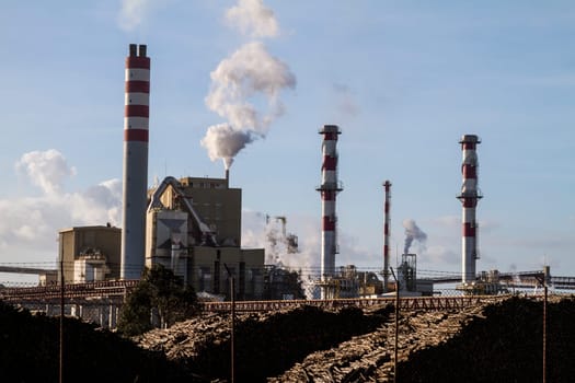 View of a industrial paper factory with tall fume towers.