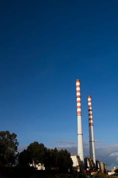 View of a industrial refinery factory with two tall fume towers.
