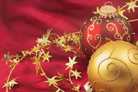 Red and gold red christmas bulbs with gold  chain on a red background