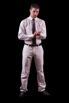View of a handsome young man on a white suit with tie isolated on a black background.