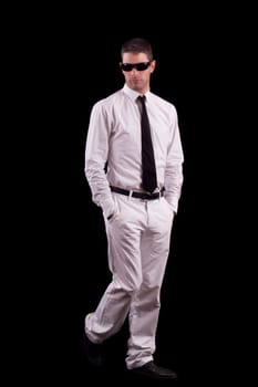 View of a handsome young man on a white suit with tie isolated on a black background.