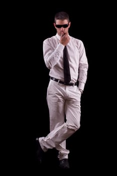 View of a handsome young man on a white suit with tie isolated on a black background.