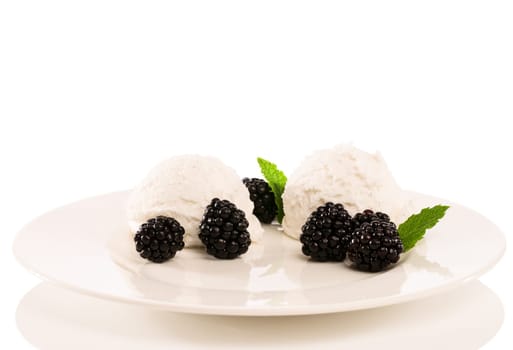 Vanilla ice cream with blackberries on a plate with mint