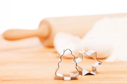 Close-up Christmas tree cookie cutter in front of baking utensils